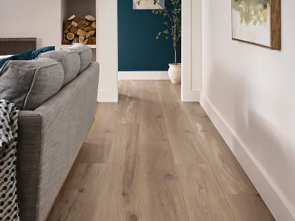 Wood Look Luxury Vinyl Plank Flooring in Modern Living Room Scene Modern living room with wood look luxury vinyl plank flooring, featuring a gray sofa and abstract wall art