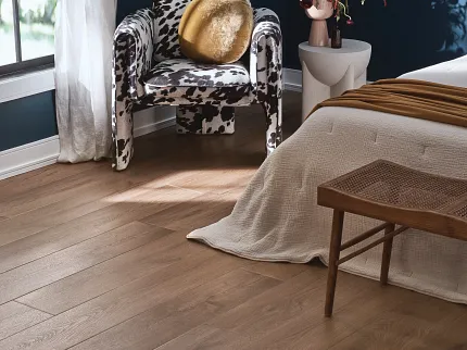 Wood Look Luxury Vinyl Plank Flooring in Stylish Bedroom Decor Cozy bedroom with wood look luxury vinyl plank flooring, featuring a cow print chair and modern decor