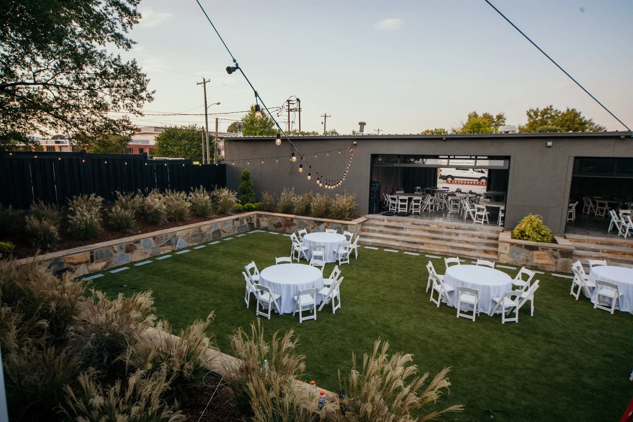 Outdoor event space with round tables and chairs on grass