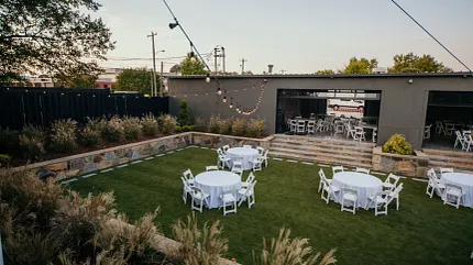 Charming outdoor venue for gatherings and celebrations Outdoor event space with round tables and chairs on grass