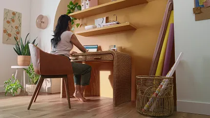 Stylish home office with wood look LVP flooring Modern home office with a woman working at a desk, featuring wood look luxury vinyl plank flooring