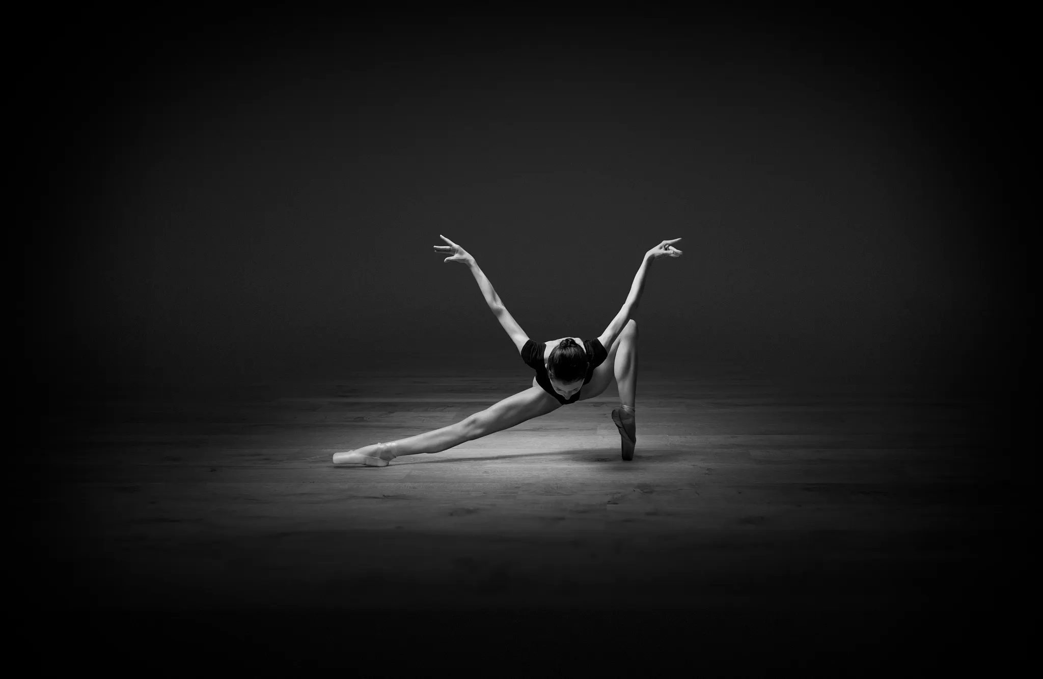 Elegant dancer performing on luxury vinyl flooring in a dimly lit room