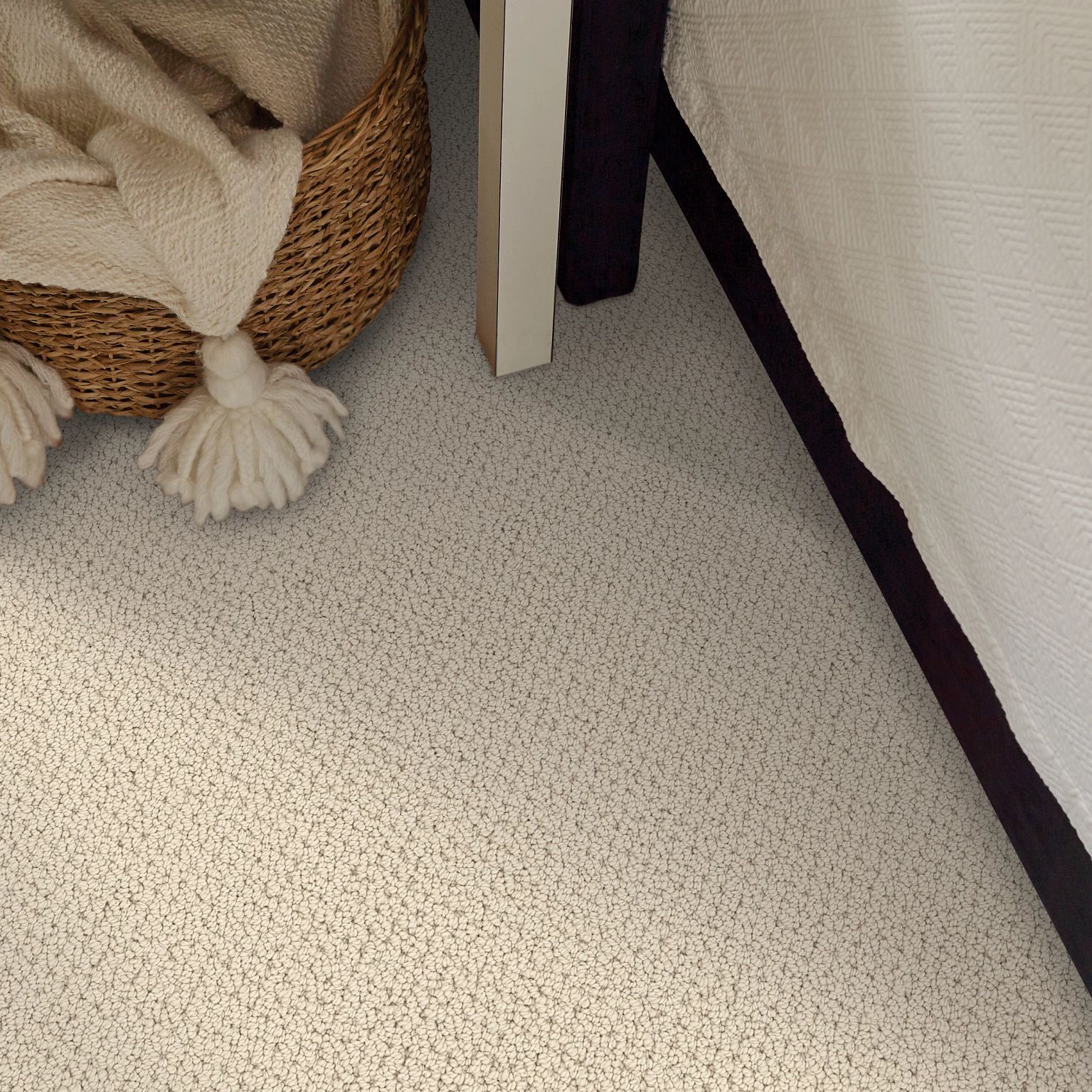A cozy beige pattern carpet floor featuring a blanket basket and SMART THINKING loop pile carpet in color Alabaster