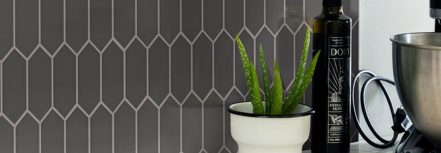 black ceramic tile backsplash in kitchen with with small cactus plant