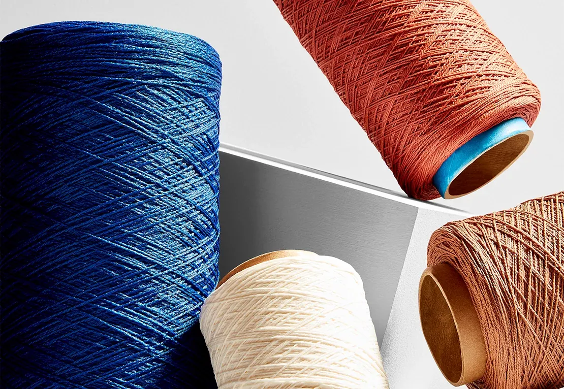 Spools of yarn in blue, white, and terracotta colors