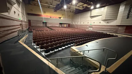 Spacious auditorium flooring for educational environments Auditorium with tiered seating and stage in an education facility