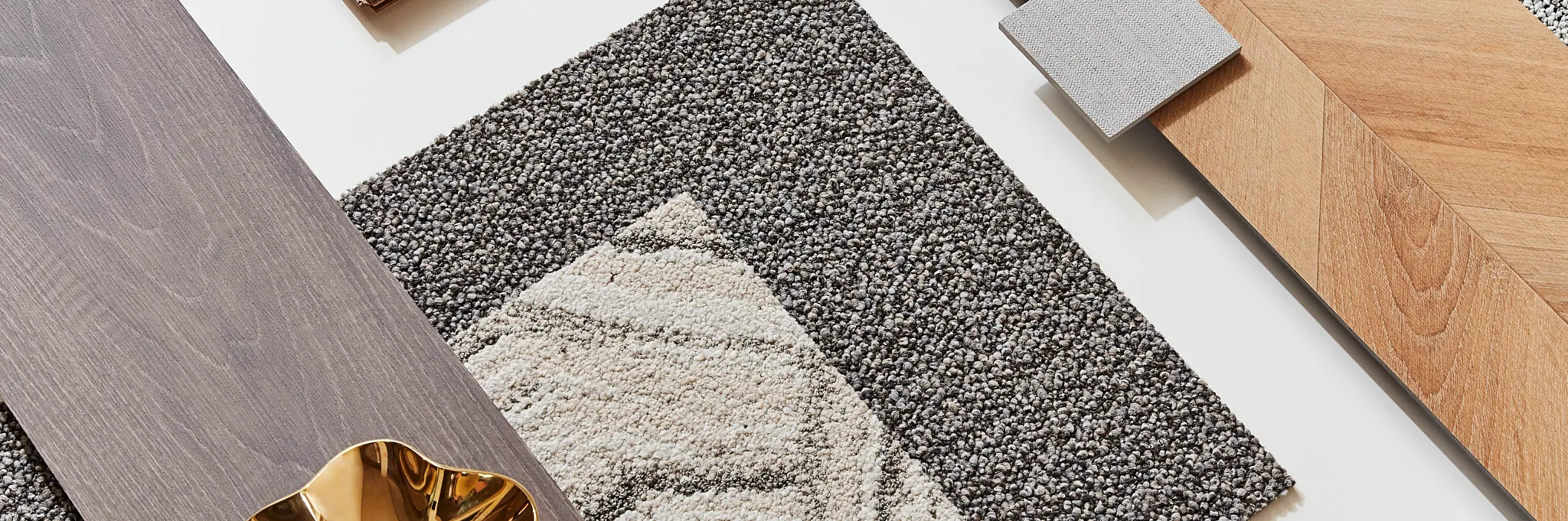 Flooring design palette featuring light and dark wood planks, textured carpet swatches in gray and beige tones, and decorative elements