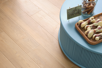 Luxury vinyl flooring with a blue table and a bowl of cookies on it.