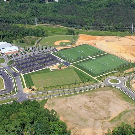 Sports Complex with Artificial Turf Fields and Baseball Diamond Aerial view of sports complex featuring artificial turf soccer fields and baseball diamond surrounded by lush greenery