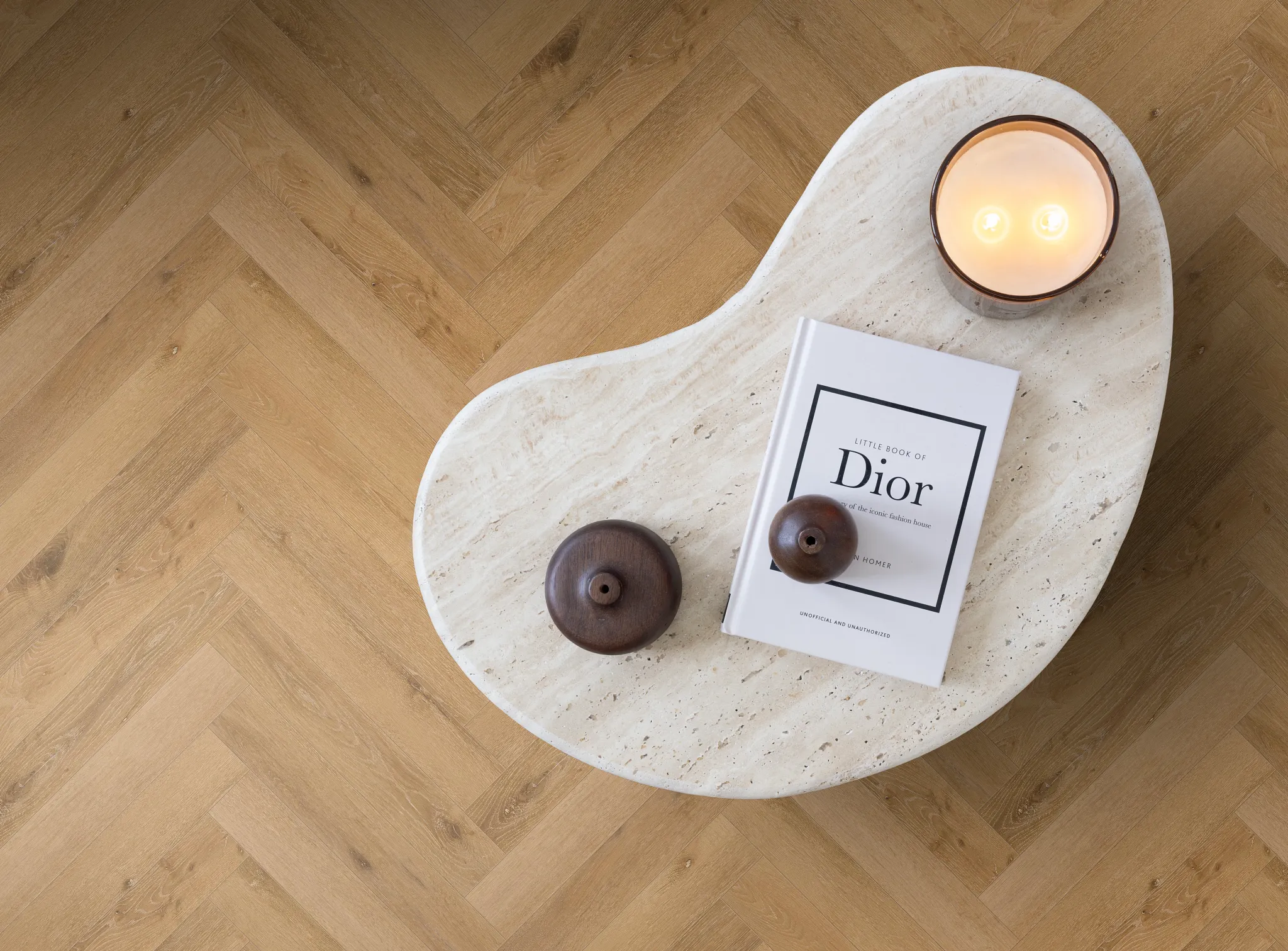 Herringbone pattern luxury vinyl flooring in a warm oak color with a modern coffee table and decor