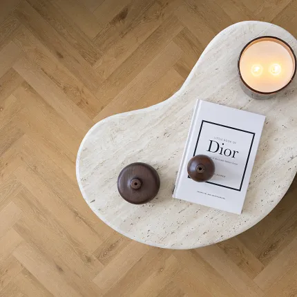 Oak Herringbone Luxury Vinyl Flooring - Stylish and Durable Design Herringbone pattern luxury vinyl flooring in a warm oak color with a modern coffee table and decor