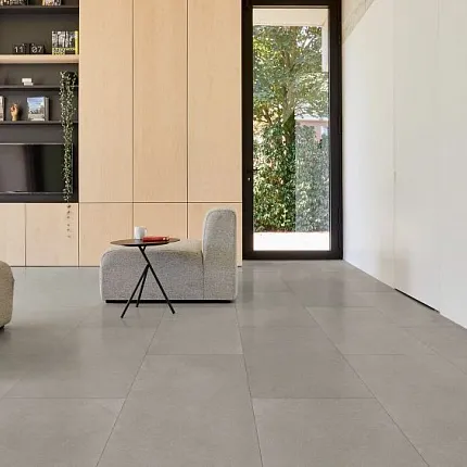 Contemporary Living Room with Stone Look Luxury Vinyl Tile Flooring Modern living room with large format stone look luxury vinyl tile flooring, beige and gray tones, contemporary furniture, and natural light from large window