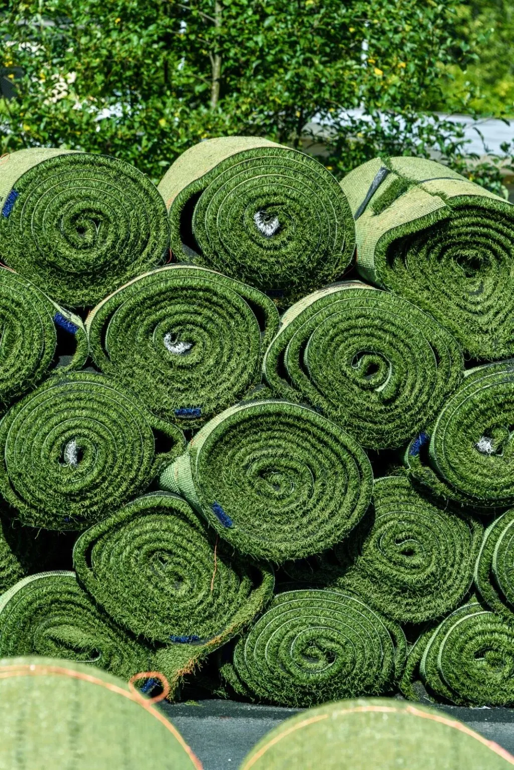 Rolls of artificial grass stacked outdoors