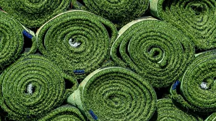 Durable artificial grass rolls for landscaping Rolls of artificial grass stacked outdoors