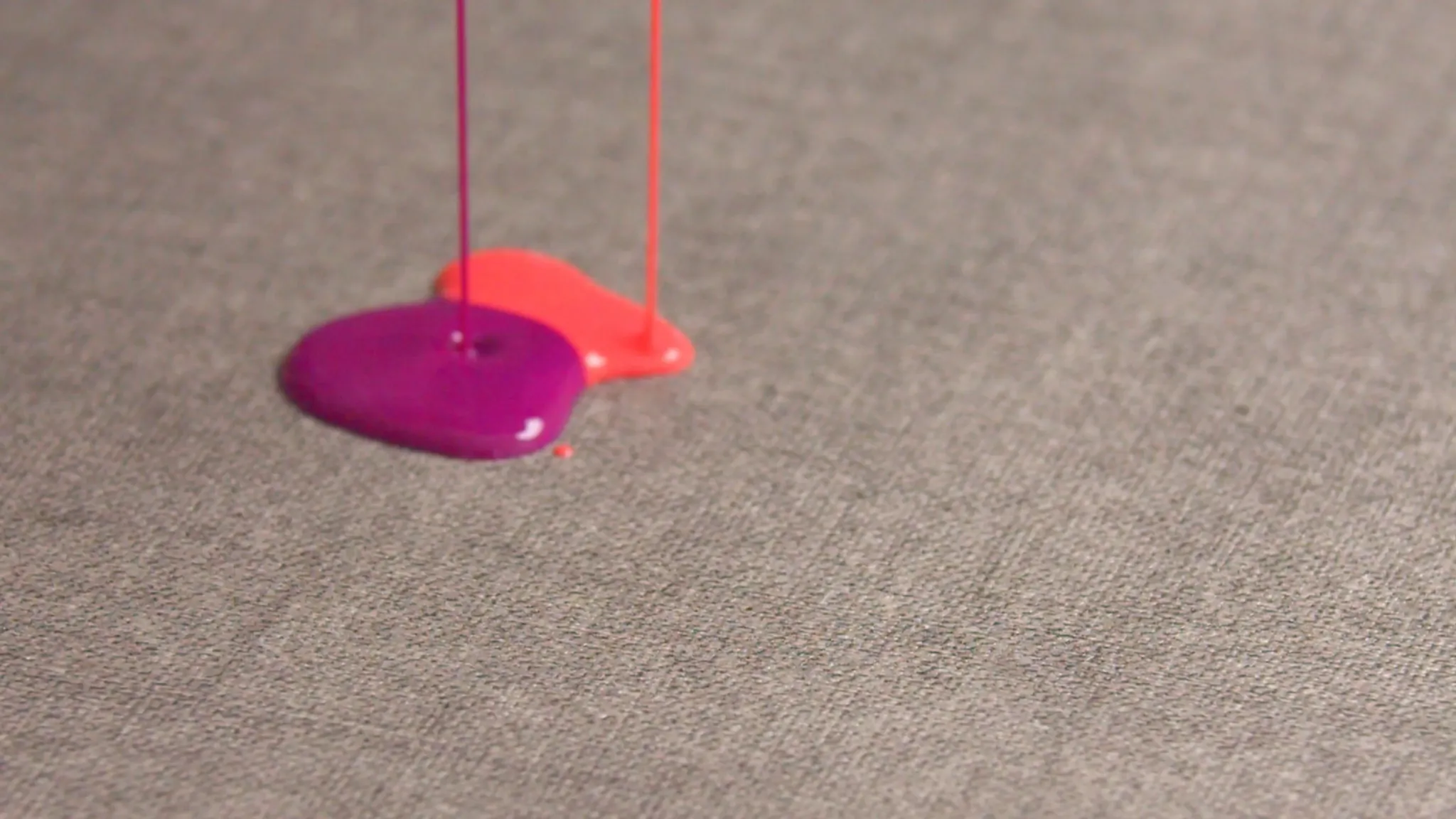Close-up of gray commercial carpet tile with pink and purple liquid spills