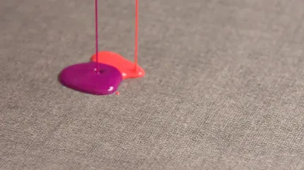 Gray Commercial Carpet Tile with Liquid Spills Close-up of gray commercial carpet tile with pink and purple liquid spills
