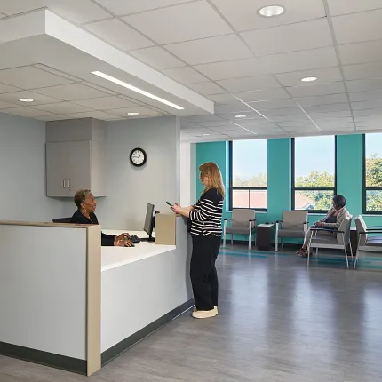 Modern Healthcare Facility Reception with Durable Flooring Healthcare facility reception area with modern flooring and two people interacting at the desk