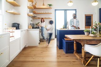 A family cooking together in a kitchen with luxury vinyl flooring and blue cabinets.