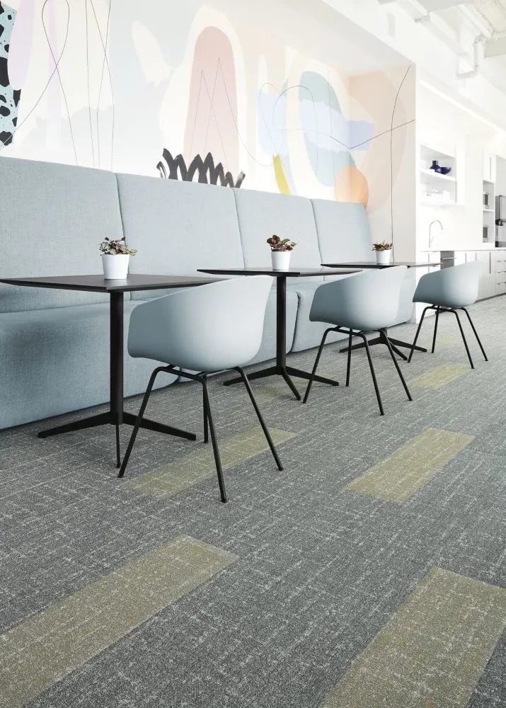 Modern education facility with light blue chairs and tables on gray and beige commercial carpet tile flooring