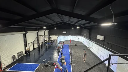 Modern gym design with vibrant flooring Gym interior with blue and gray flooring