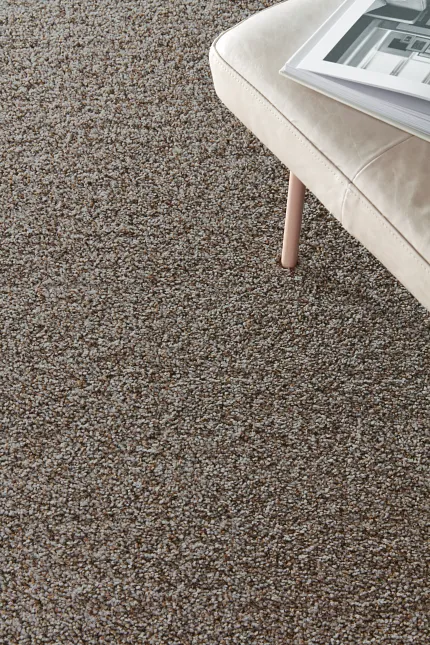 Textured Brown and Gray Carpet Flooring with Beige Leather Chair and Open Book
