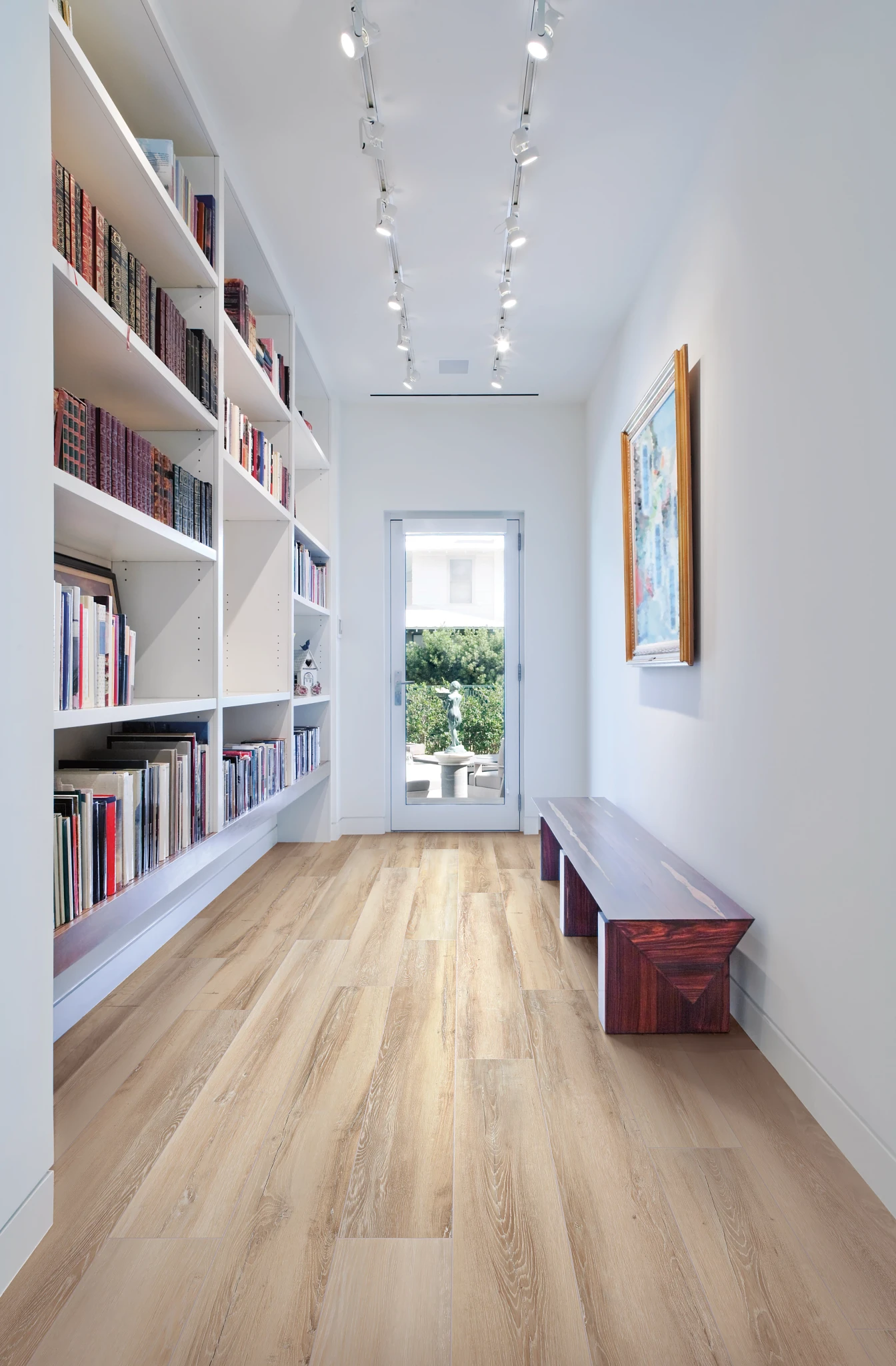Light wood look vinyl flooring in a modern hallway with bookshelves