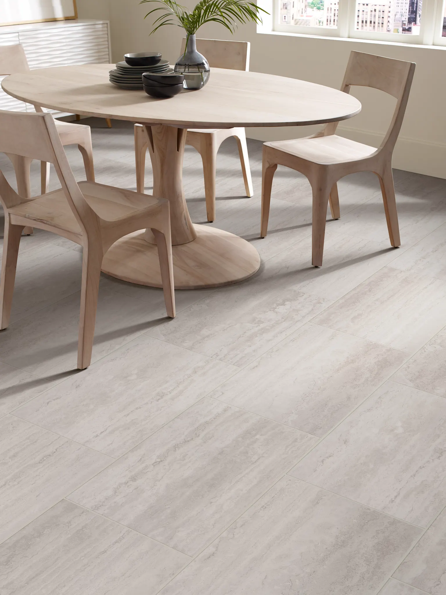 Modern dining room with light wood furniture and durable light gray tile flooring