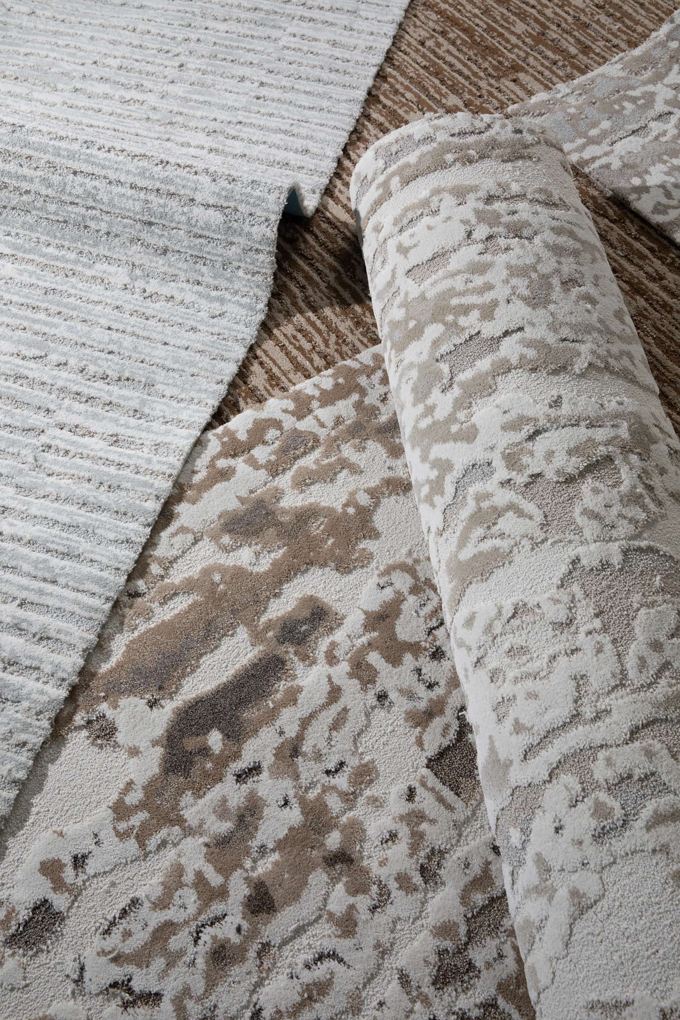 several loose rolls of carpet in exquisite patterns