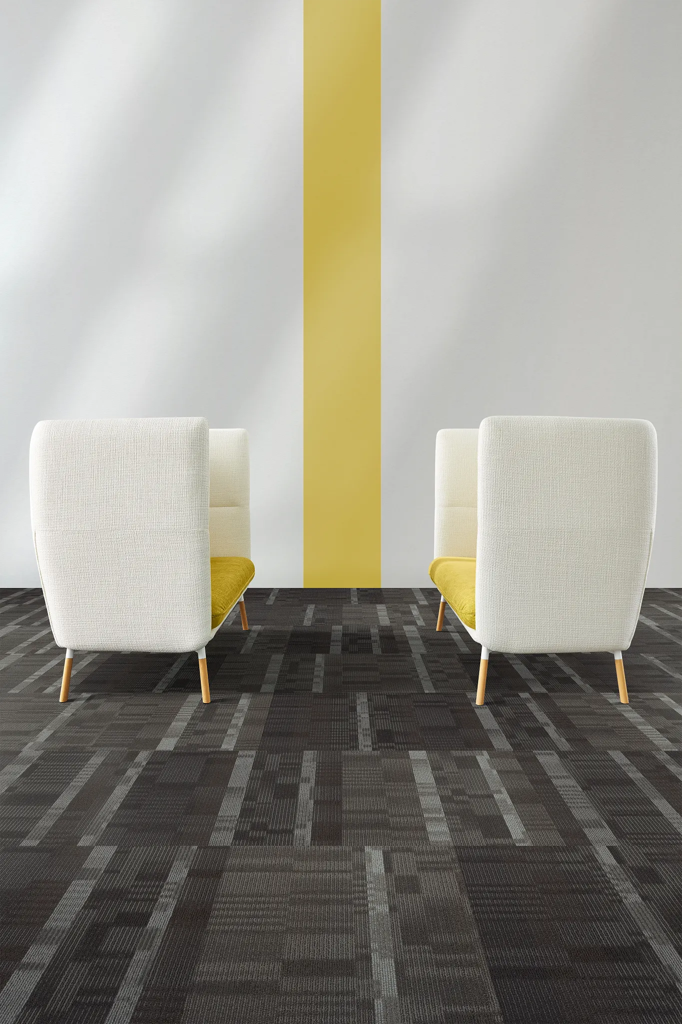 Modern office space with two white and yellow chairs on dark patterned carpet flooring