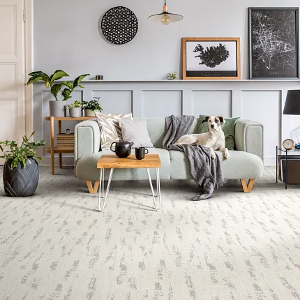 Contemporary living room with light gray carpet flooring and stylish decor. living room with light gray patterned carpet floor with a light green sofa wooden coffee table and decorative plants