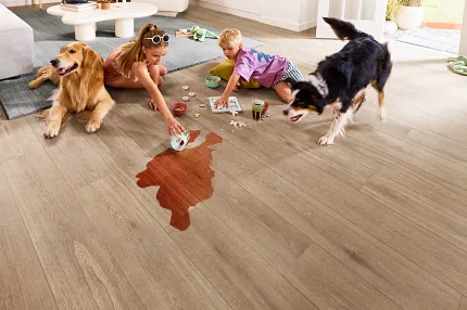 Durable Hardwood Flooring for Comfortable Family Living Spaces. Family-friendly living room with durable hardwood flooring, featuring a playful scene with children and dogs, showcasing easy-to-clean and pet-friendly flooring.