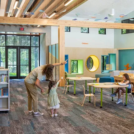 Education Facility with Commercial Carpet Tile Flooring and Wooden Beams Education facility with commercial carpet tile flooring in shades of blue and gray, featuring wooden beams and modern lighting