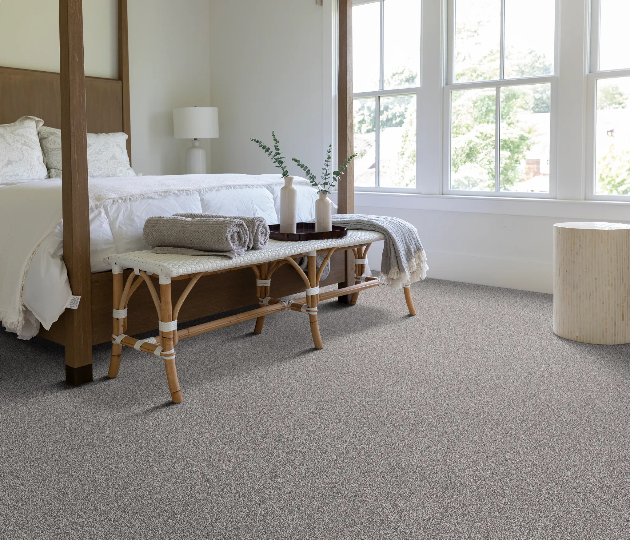 Cozy bedroom with a four-poster bed and neutral carpet flooring
