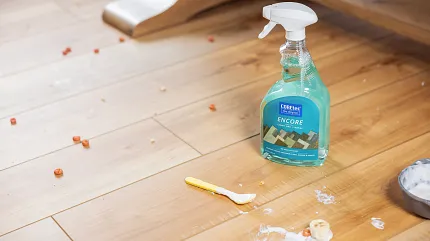 Durable and easy-to-clean luxury vinyl plank flooring in a residential setting Luxury vinyl plank flooring with cleaning spray and scattered food debris