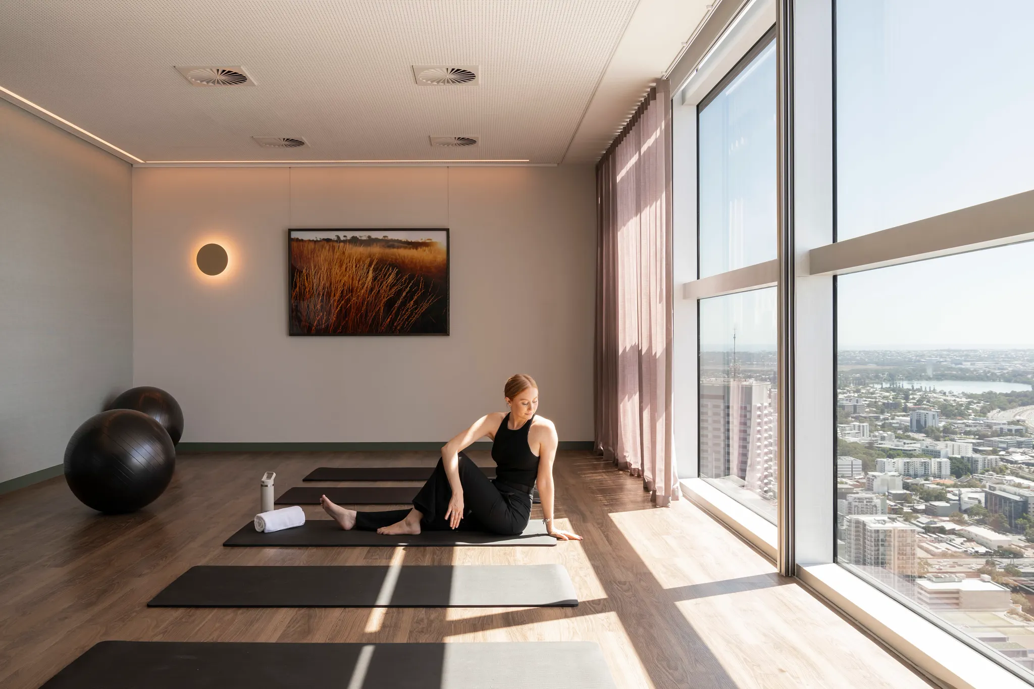 Modern yoga studio with wood flooring and city view