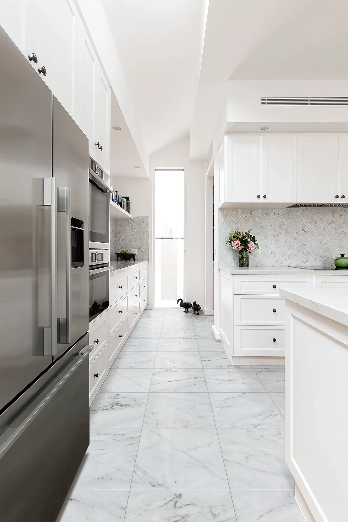 Modern kitchen with white cabinets and stainless steel appliances featuring marble-look luxury vinyl tile flooring