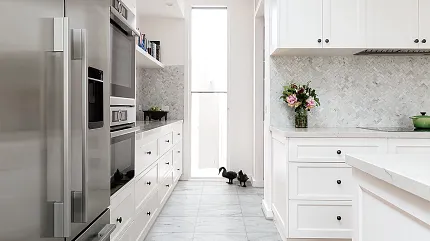 Marble-look luxury vinyl tile flooring in a contemporary kitchen setting Modern kitchen with white cabinets and stainless steel appliances featuring marble-look luxury vinyl tile flooring