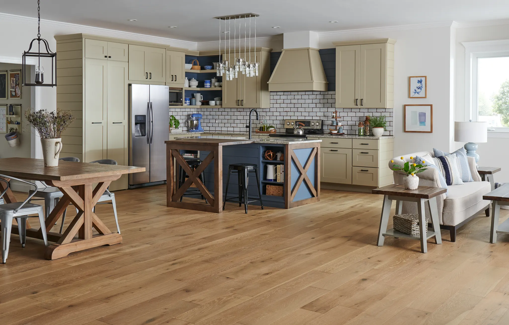 kitchen with light wood engineered hardwood floor with beige cabinets stainless steel appliances and a dining area