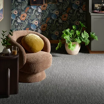 Premium 12 ft Wide Gray Broadloom Carpet for Modern Interiors Elegant gray broadloom carpet in a stylish living room with a plush chair and vibrant plants