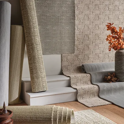 Textured Beige and Gray Carpet Collection Variety of textured carpet rolls in shades of beige and gray displayed in a cozy room setting