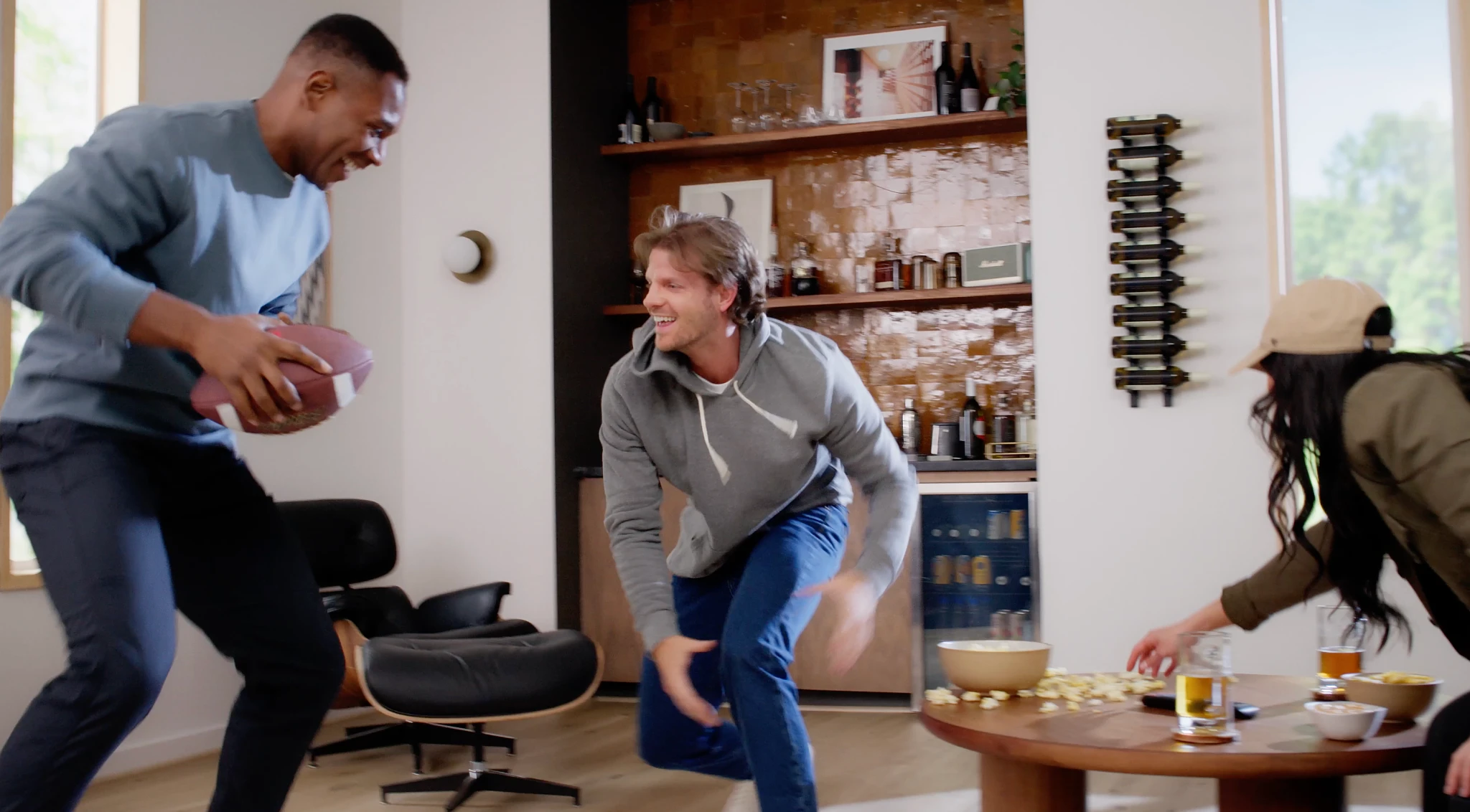 Modern living room with young adults playing, showcasing luxury vinyl plank flooring with a wood look finish