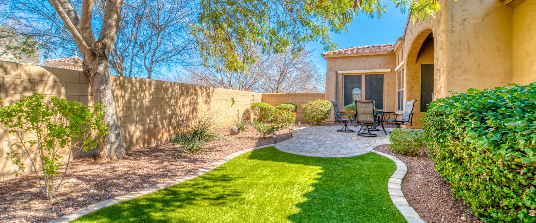 Outdoor patio with lush green lawn and garden