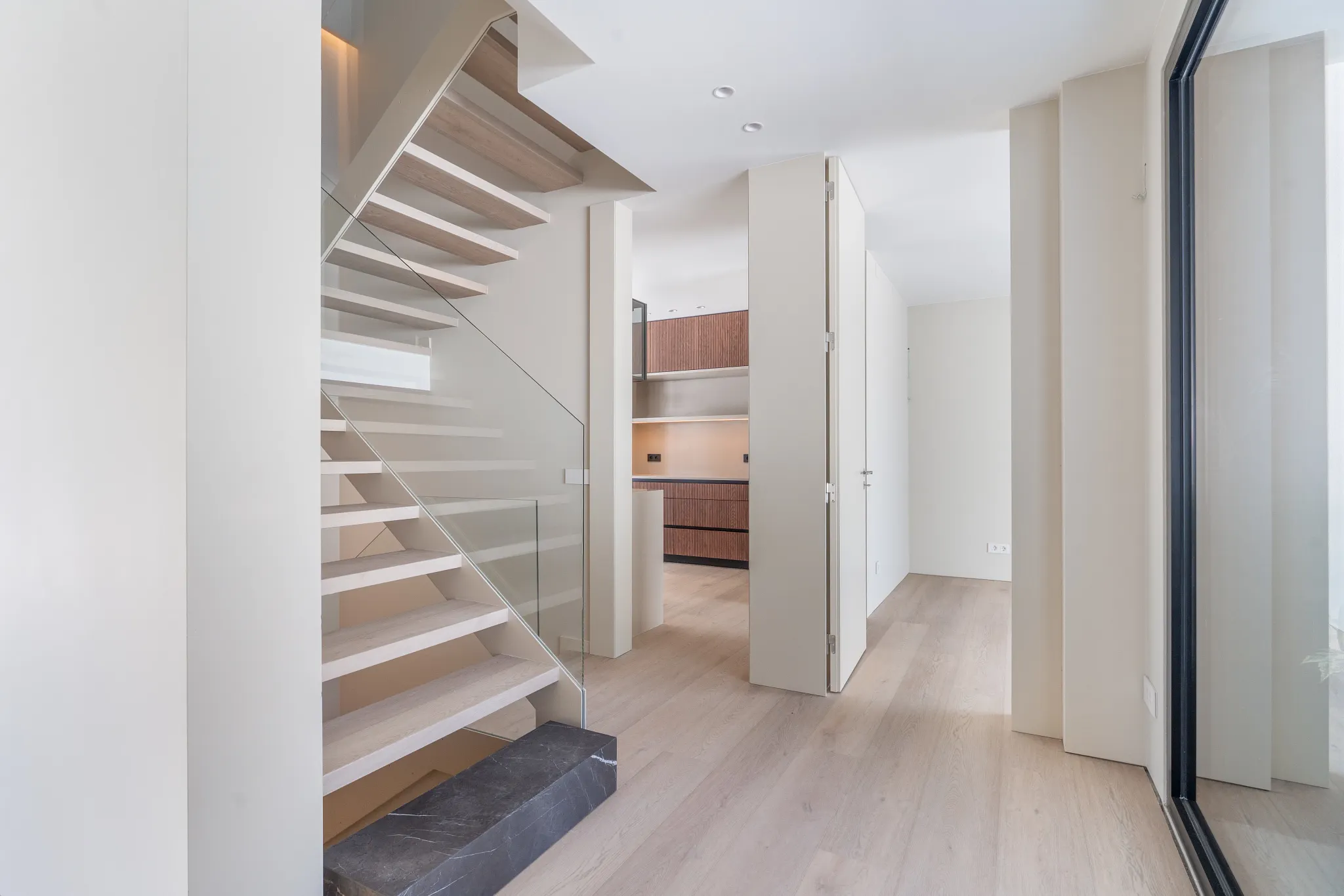 Modern interior with wooden floors and walnut kitchen cabinets