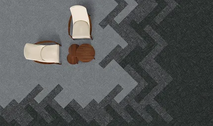 Modern seating area with commercial carpet tile flooring in grey and dark grey pattern Overhead view of a modern seating area with two cream chairs and a wooden table on a patterned grey and dark grey commercial carpet tile floor