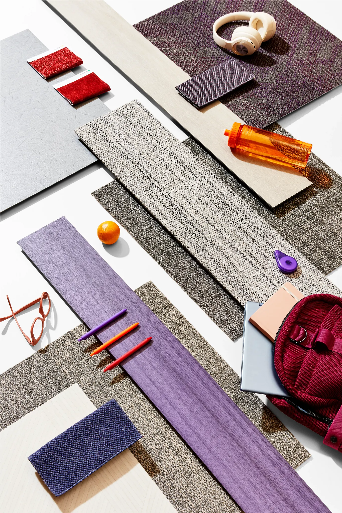 Assorted carpet tile samples in red, purple, and beige colors