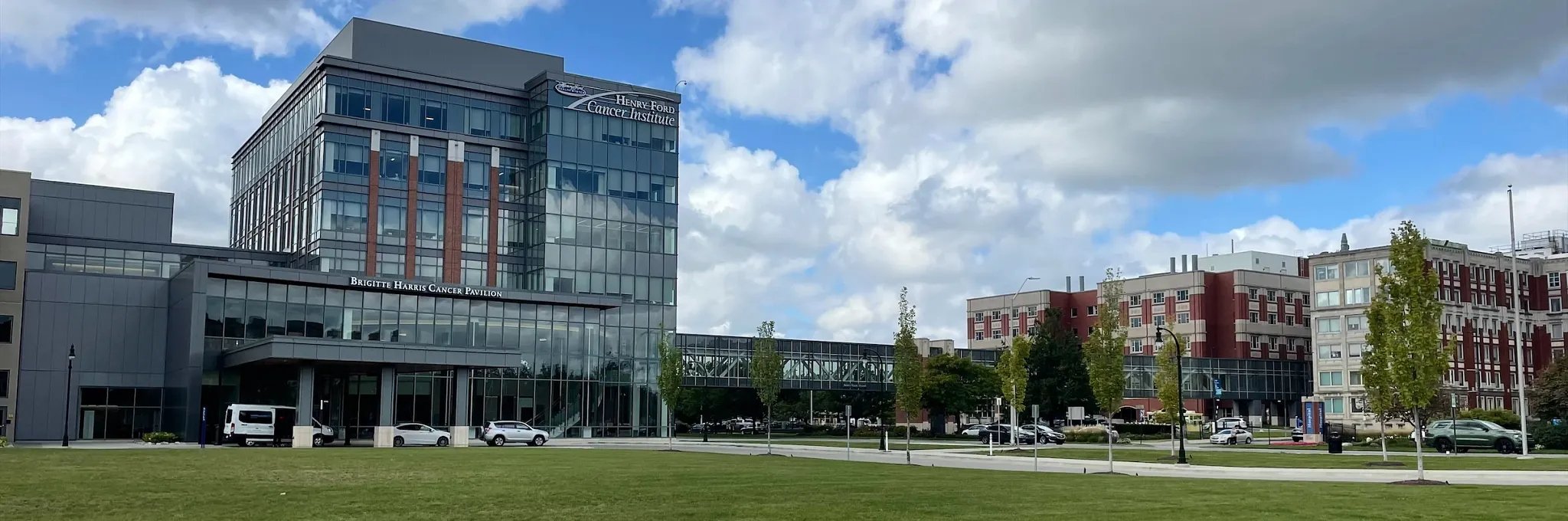 Modern building with glass facade and green lawn under blue sky