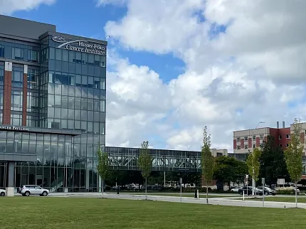 Contemporary architecture with lush landscape Modern building with glass facade and green lawn under blue sky