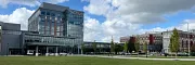 Contemporary architecture with lush landscape Modern building with glass facade and green lawn under blue sky