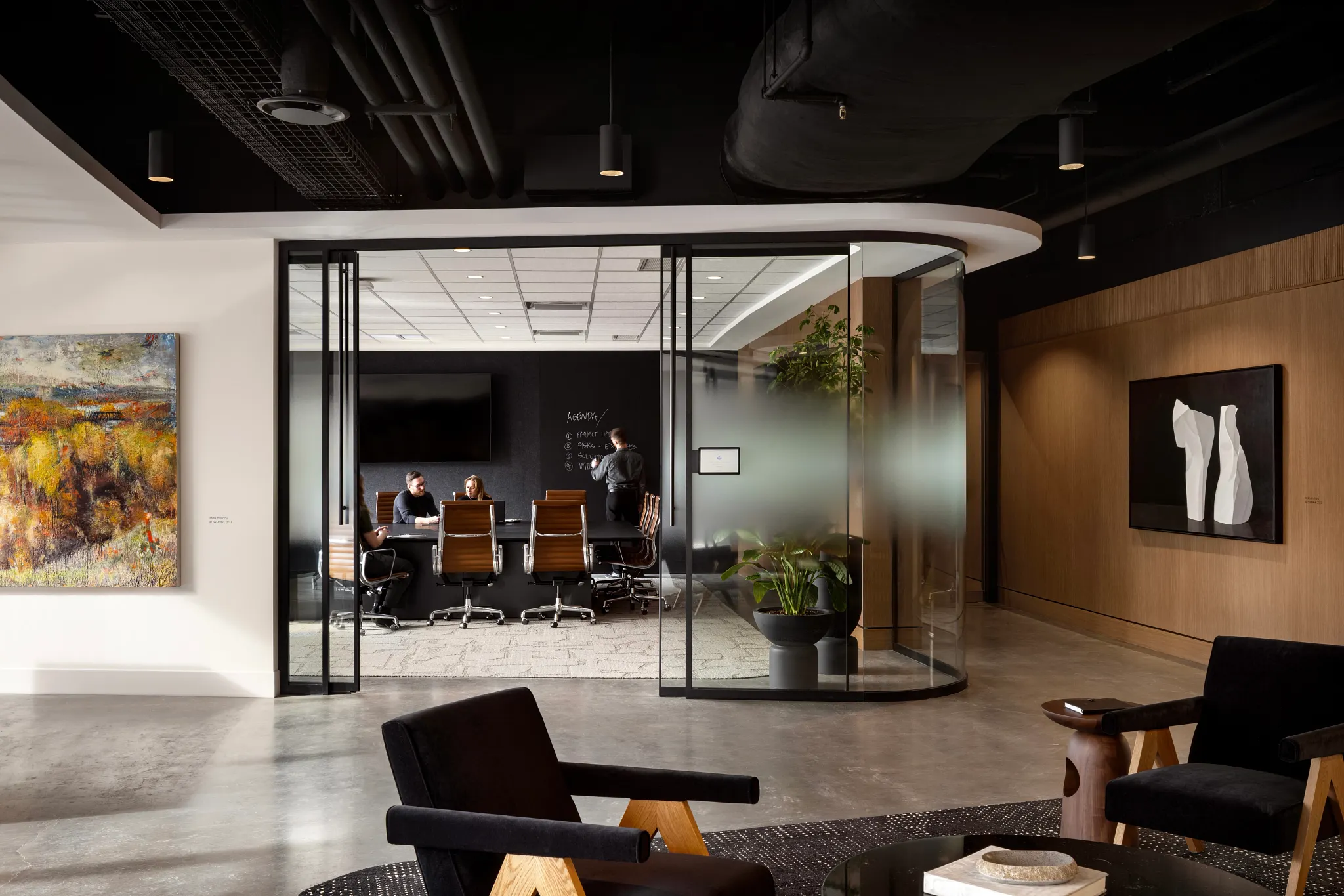 Espacio de oficina moderno con piso de concreto y sala de reuniones de vidrio