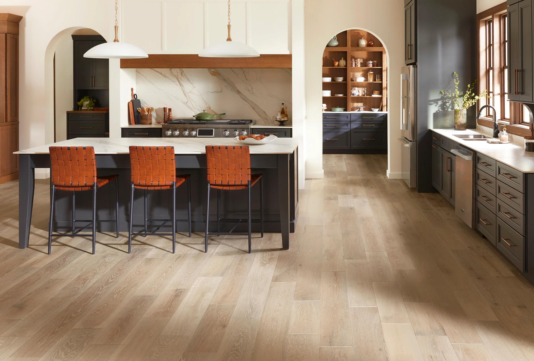 Elegant kitchen with light brown hardwood flooring featuring wide planks in a modern home